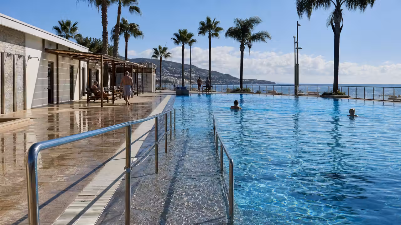 Bassin extérieur rénové au bord de la mer, avec accès en pente et plages de piscine dégagées