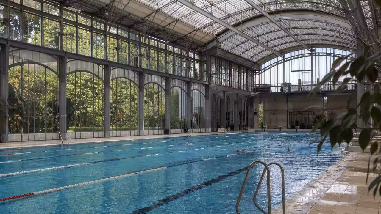 Bassin de 25 mètres sous une halle lumineuse d’une piscine publique rénovée à Bordeaux