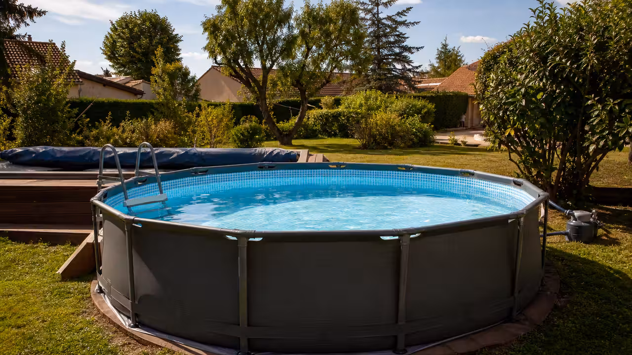 Piscine hors-sol tubulaire installée sur un terrain nivelé dans un jardin familial en été