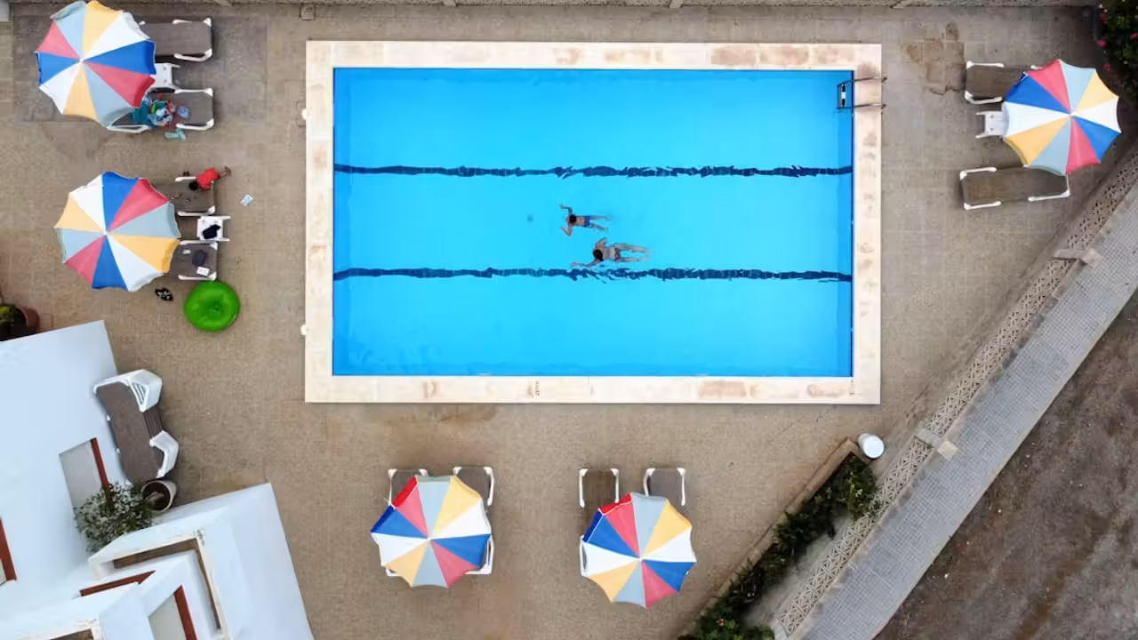 Bassin de natation d’un centre aquatique public avec lignes d’eau et maître-nageur au bord du bassin