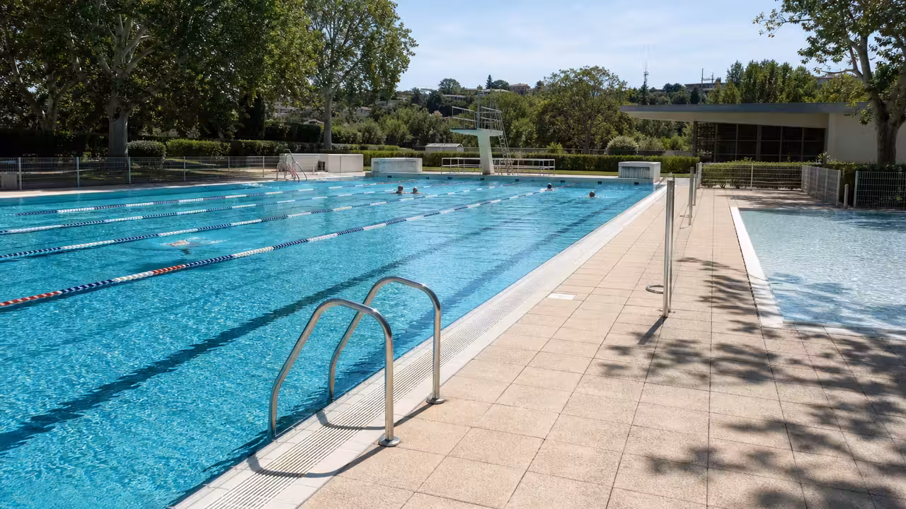 Bassin extérieur de 25 mètres et espaces verts d’une piscine municipale par une journée d’été