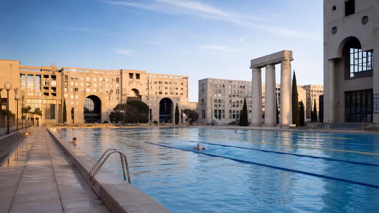 Bassin de nage de 50 mètres dans une piscine publique montpelliéraine, lignes d’eau et architecture minérale