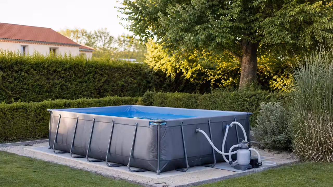 Piscine tubulaire rectangulaire installée sur un sol nivelé dans un jardin familial en été