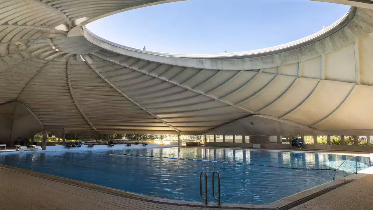 Coupole circulaire d’une piscine Tournesol municipale ouverte sur le ciel par une journée lumineuse