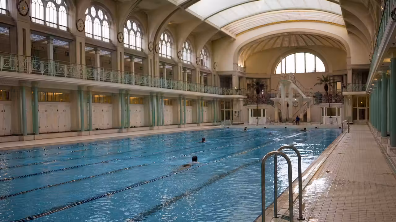 Bassin intérieur de la piscine Château-Landon à Paris, sous une voûte restaurée éclairée par la lumière du jour