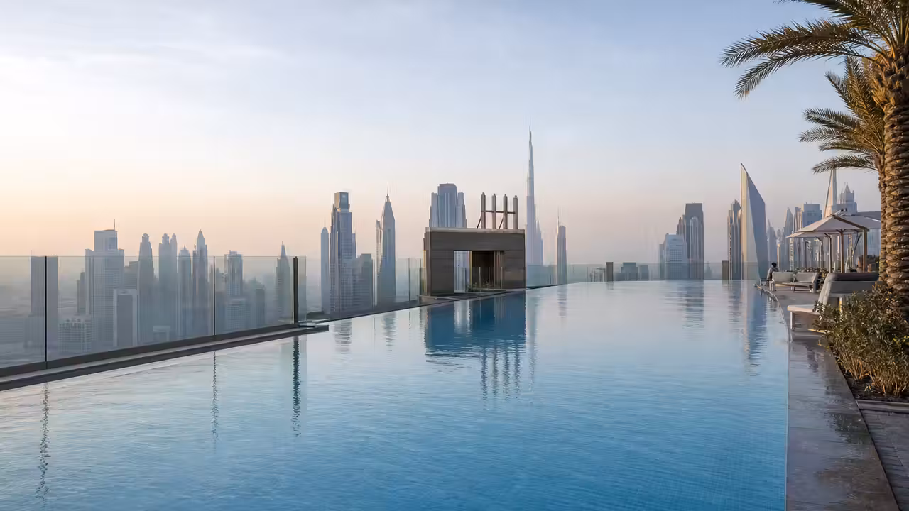 Bassin à débordement installé au sommet d’une tour moderne face au paysage urbain de Dubaï