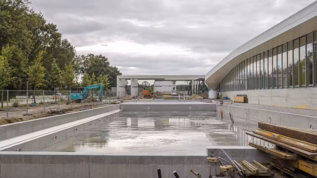 Chantier d’extension d’un centre aquatique avec structures de bassin extérieur et engins de travaux près de Nantes