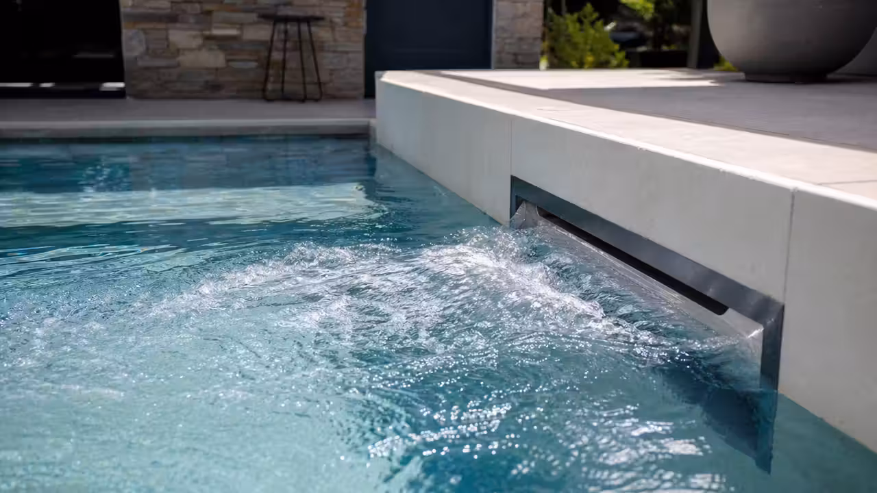 Système de nage à contre-courant encastré sur la paroi d’une piscine familiale en plein jour