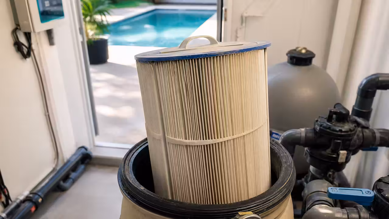 Filtre à cartouche ouvert dans un local technique de piscine, avec cartouche plissée visible