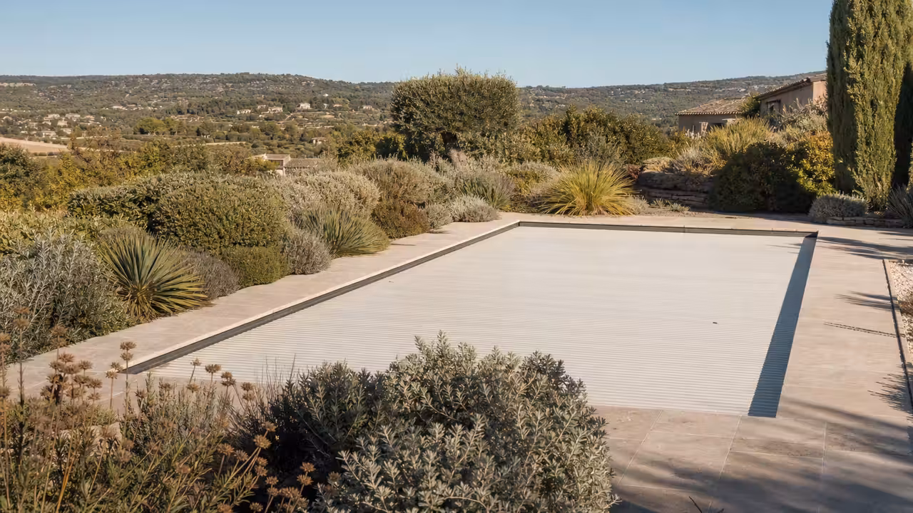 Piscine privée couverte dans un jardin méditerranéen sec, avec collines et végétation sobre en arrière-plan