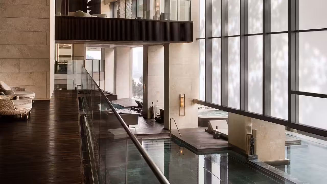 Intérieur contemporain d’un spa d’hôtel avec bassin chauffé, pierre claire et lumière naturelle tamisée
