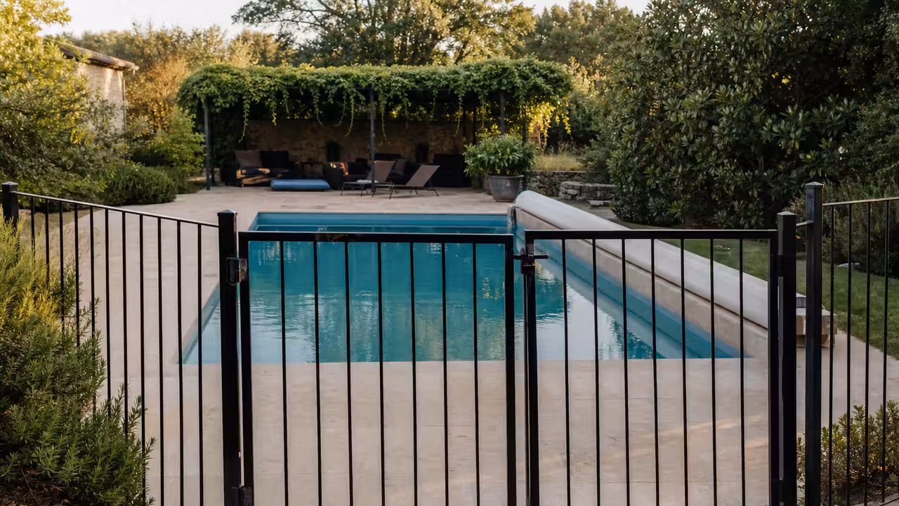 Portillon sécurisé devant une piscine privée entretenue, prête à accueillir des baigneurs en été