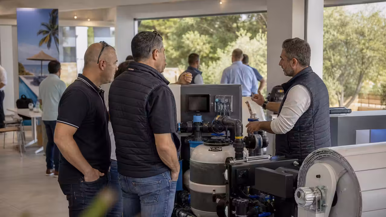 Professionnels échangeant autour d’un équipement de filtration lors d’un rendez-vous piscine à Fréjus