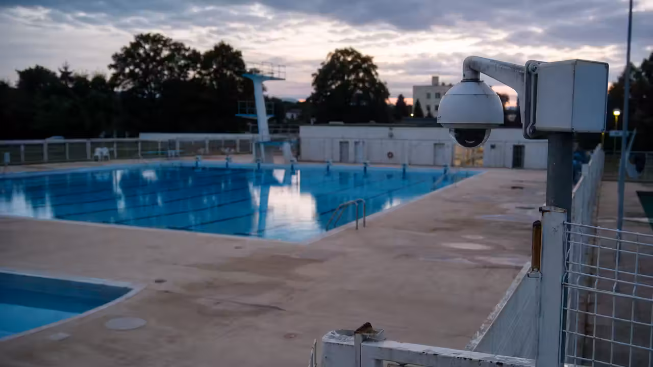 Caméra de vidéoprotection orientée vers l’entrée clôturée d’une piscine publique après la fermeture