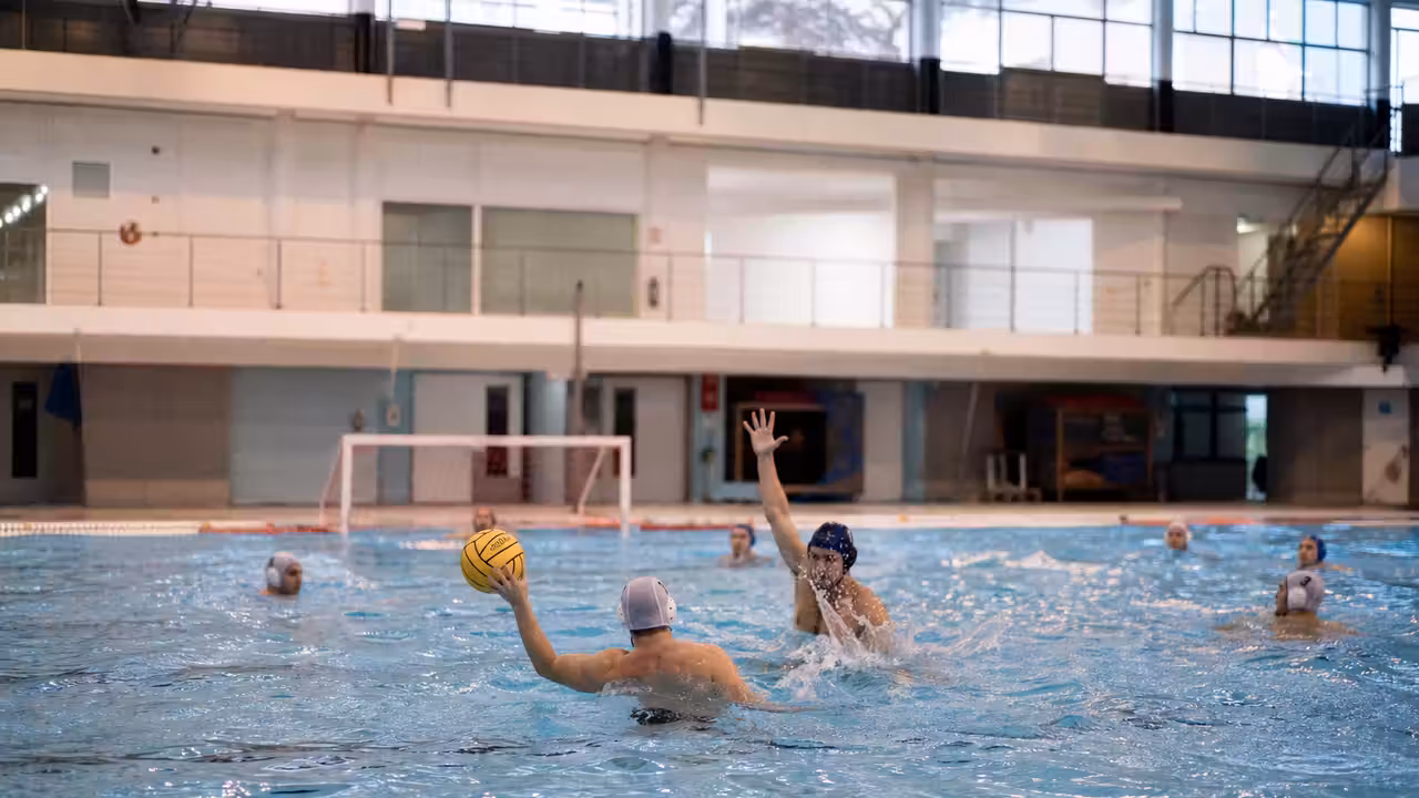 Joueurs de water-polo s’entraînant avec un ballon dans un bassin couvert de 25 mètres