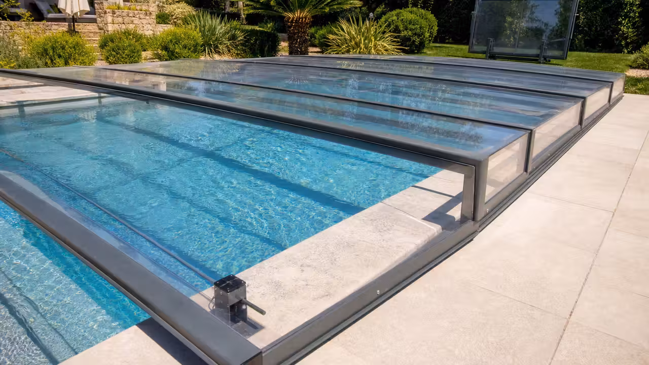 Abri bas amovible en aluminium et polycarbonate posé sur une piscine familiale bordée de margelles