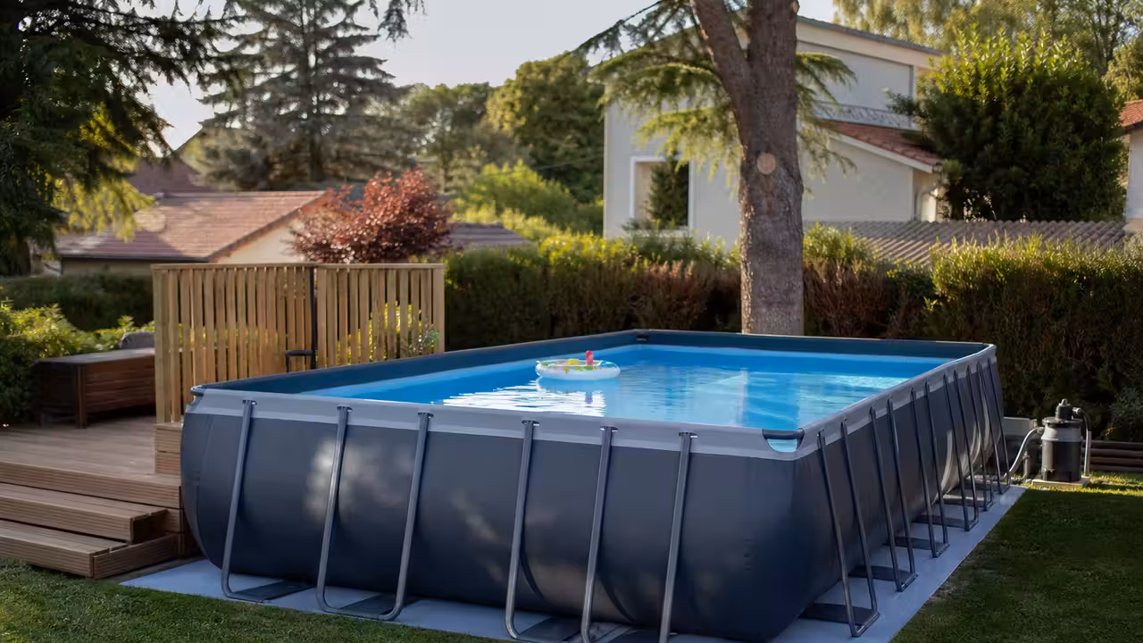 Piscine hors-sol tubulaire installée sur un jardin nivelé, avec filtration et terrasse en bois