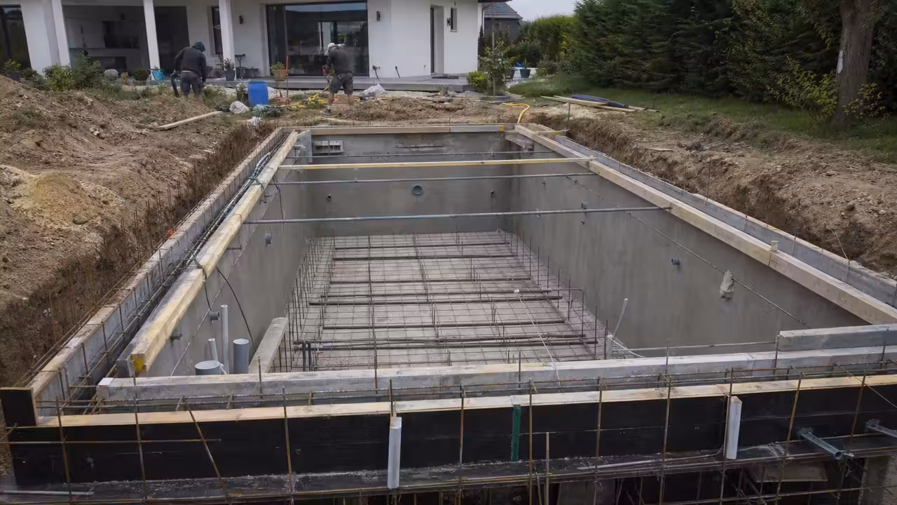 Piscine rectangulaire en béton en chantier, avec ferraillage visible et terrassement avant la pose du revêtement
