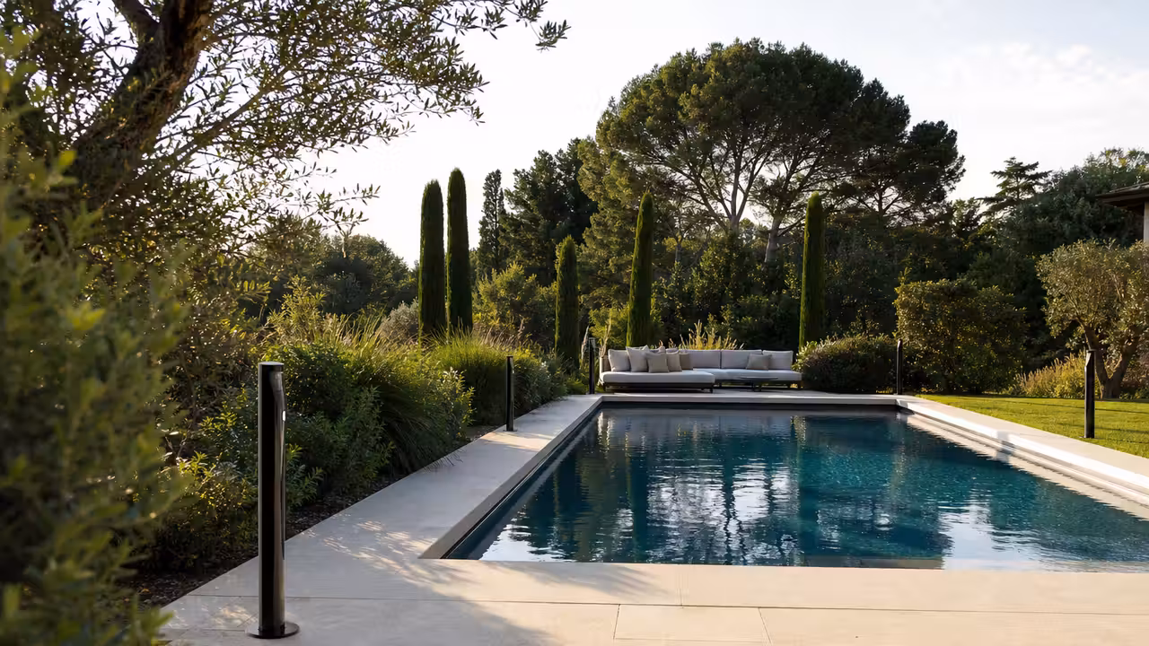 Bornes d’alarme infrarouge discrètes installées autour d’une piscine privée bordée d’une terrasse.