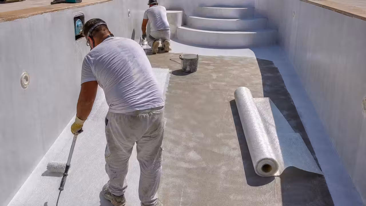 Application d'un revêtement polyester blanc dans une piscine maçonnée en cours de rénovation