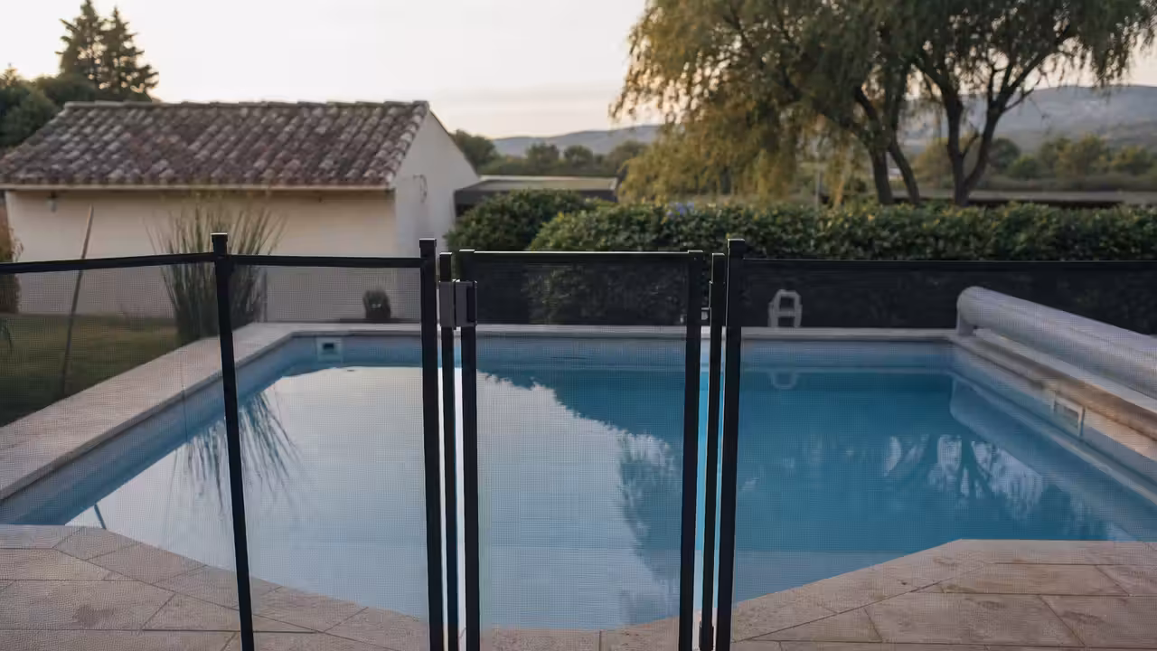 Portillon de barrière de sécurité fermé autour d'une piscine familiale enterrée en extérieur