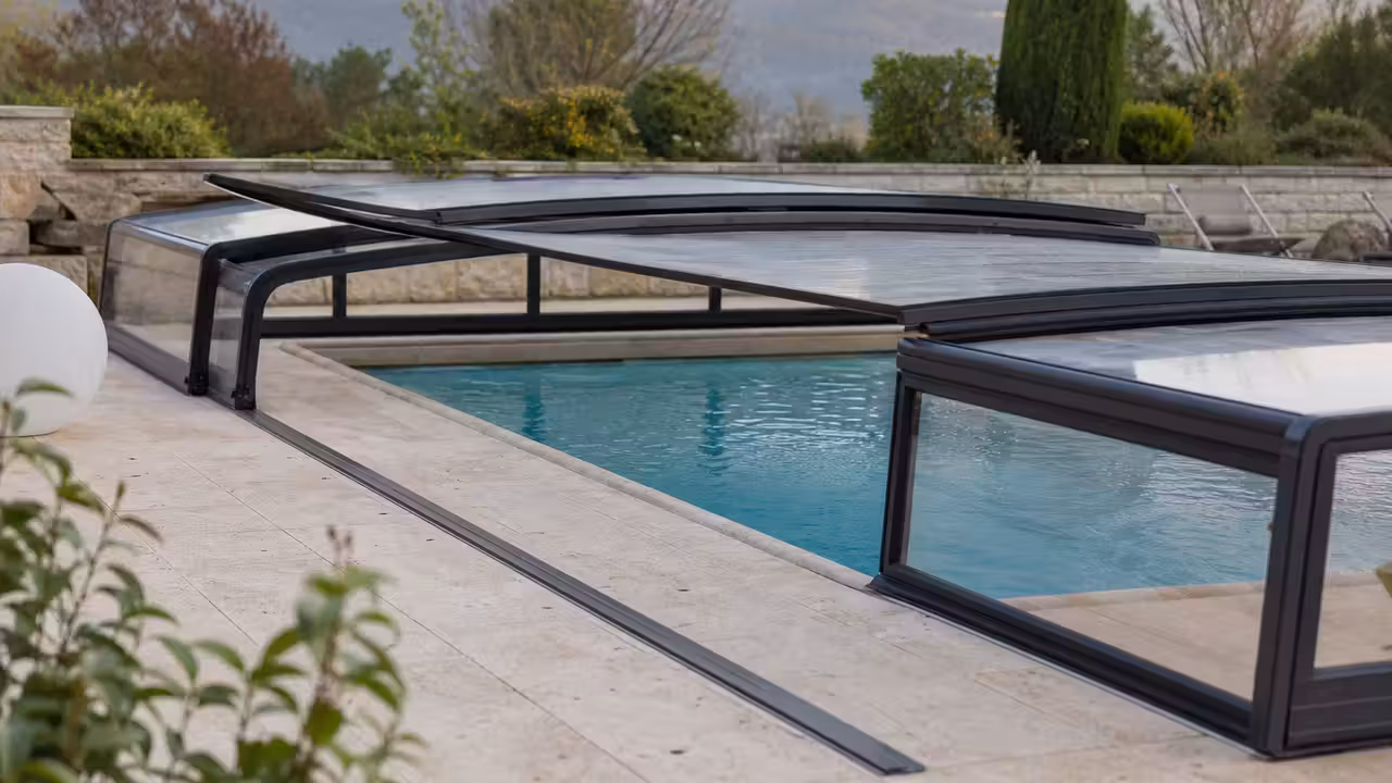Abri bas télescopique en aluminium et panneaux de polycarbonate au-dessus d’une piscine familiale