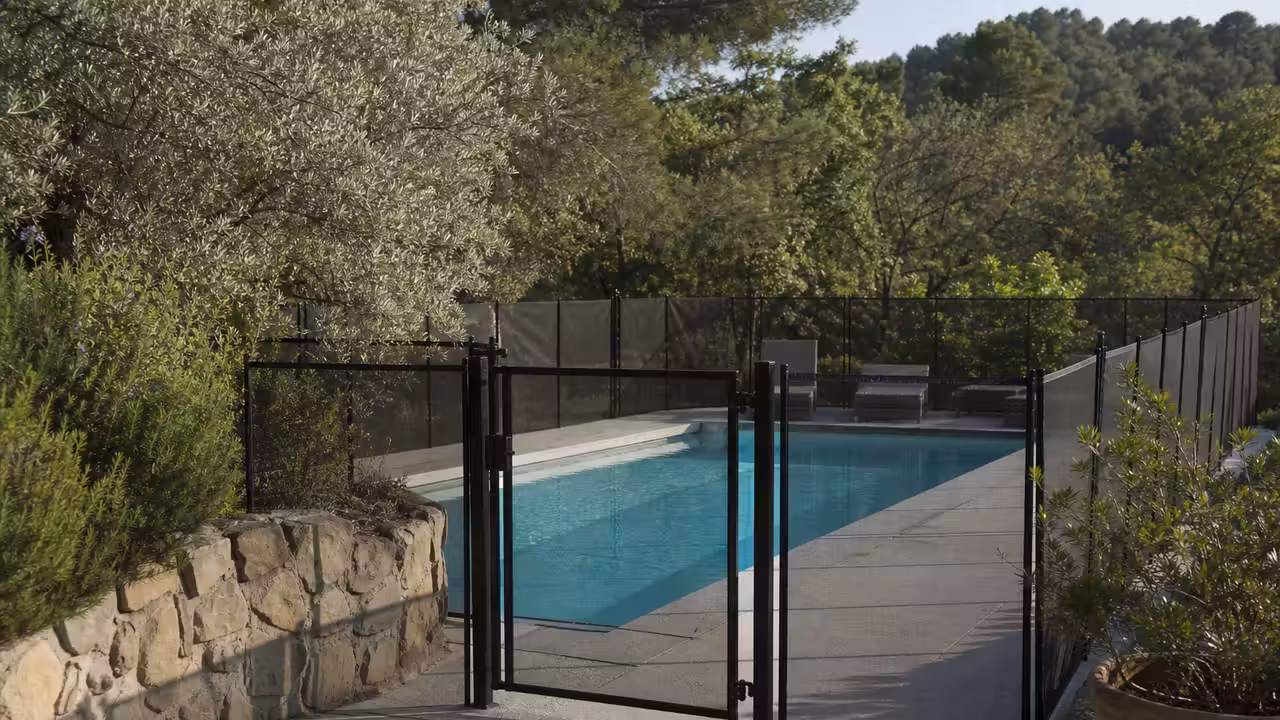Portillon verrouillable d’une barrière de sécurité installé autour d’une piscine privée enterrée