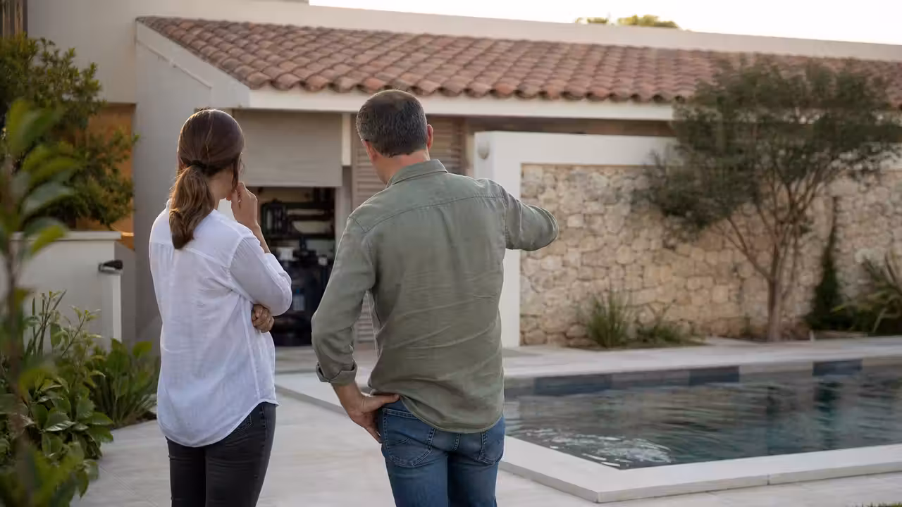 Famille vue de dos près d’une petite piscine contemporaine intégrée à une terrasse de jardin végétalisée