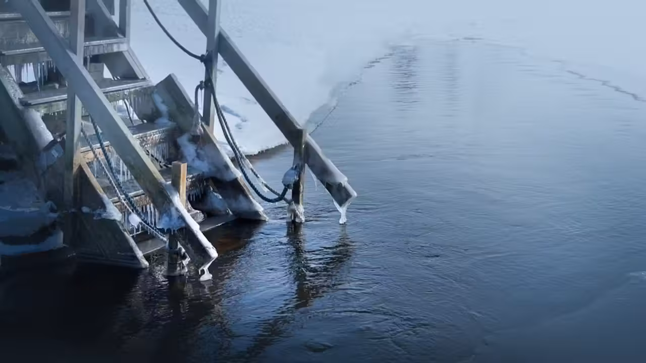 Nageur équipé d’un bonnet et de chaussons sortant d’un bassin extérieur froid en hiver