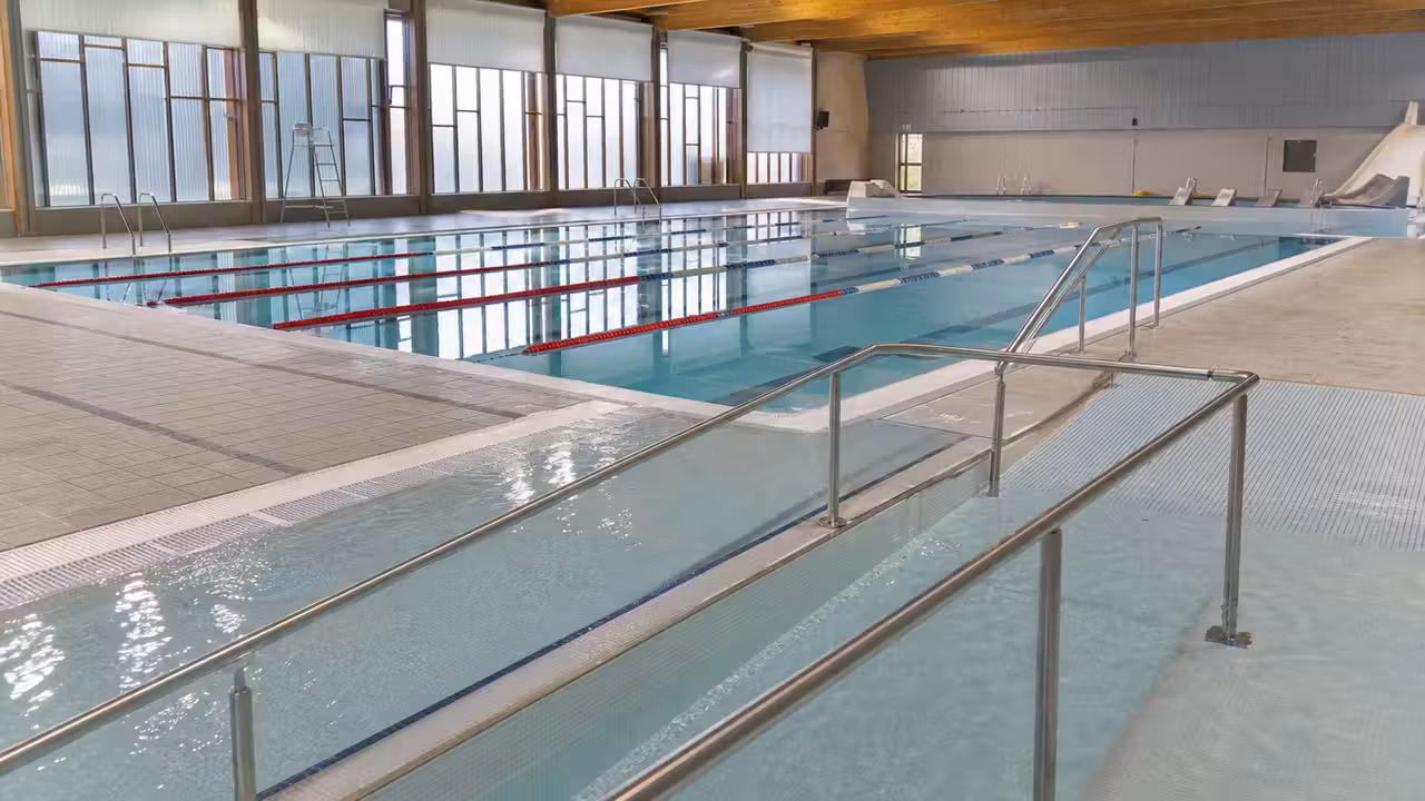 Bassin municipal rénové de 25 mètres avec lignes d’eau, plages antidérapantes et accès par rampe