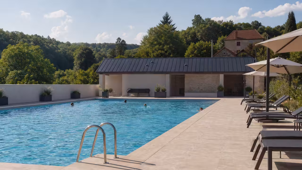 Vestiaires rénovés et plage ombragée d’une piscine municipale de plein air en début de saison