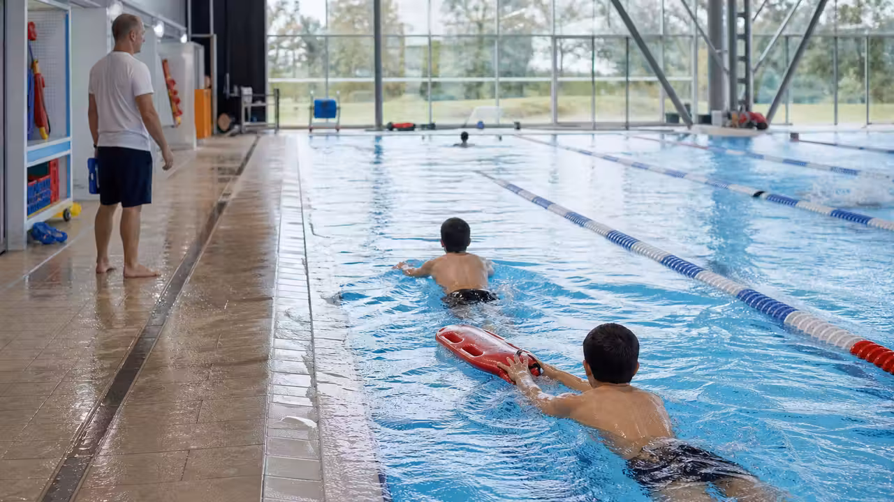 Exercice de remorquage avec flotteur pendant une séance de sauvetage en piscine