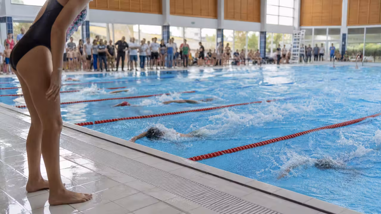 Jeunes nageurs dans un bassin de 25 mètres lors d’une compétition interclubs en piscine municipale