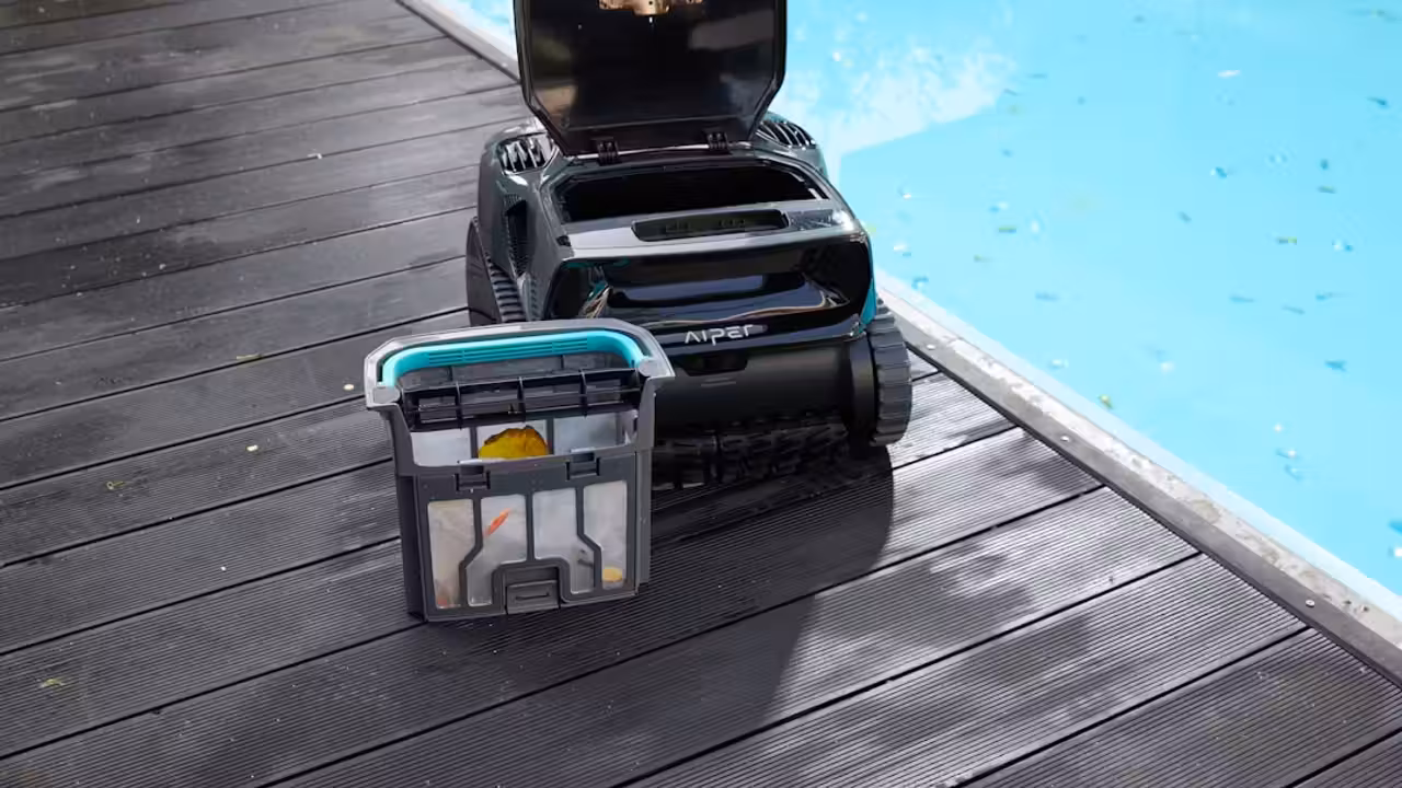 Robot nettoyeur sans fil progressant au fond d’une piscine privée, près d’une paroi immergée.