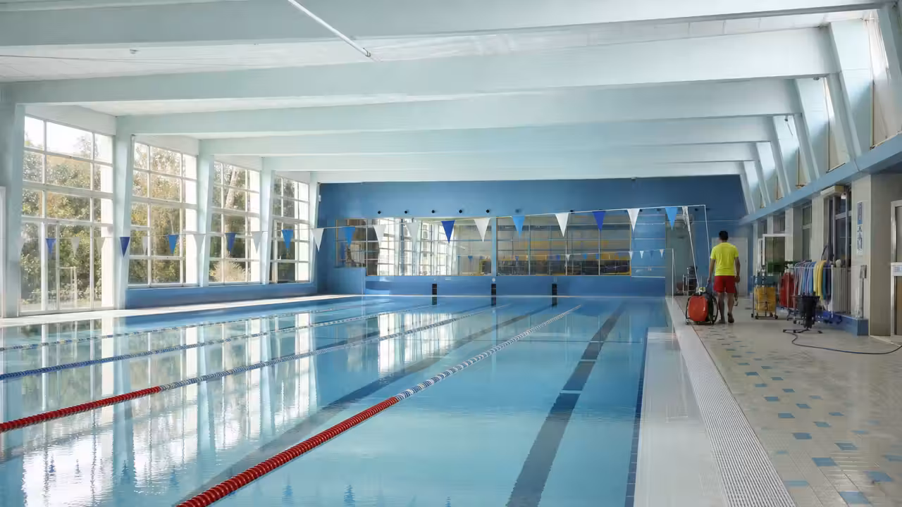 Couloir de nage vide dans une piscine municipale éclairée avant la reprise des activités sportives