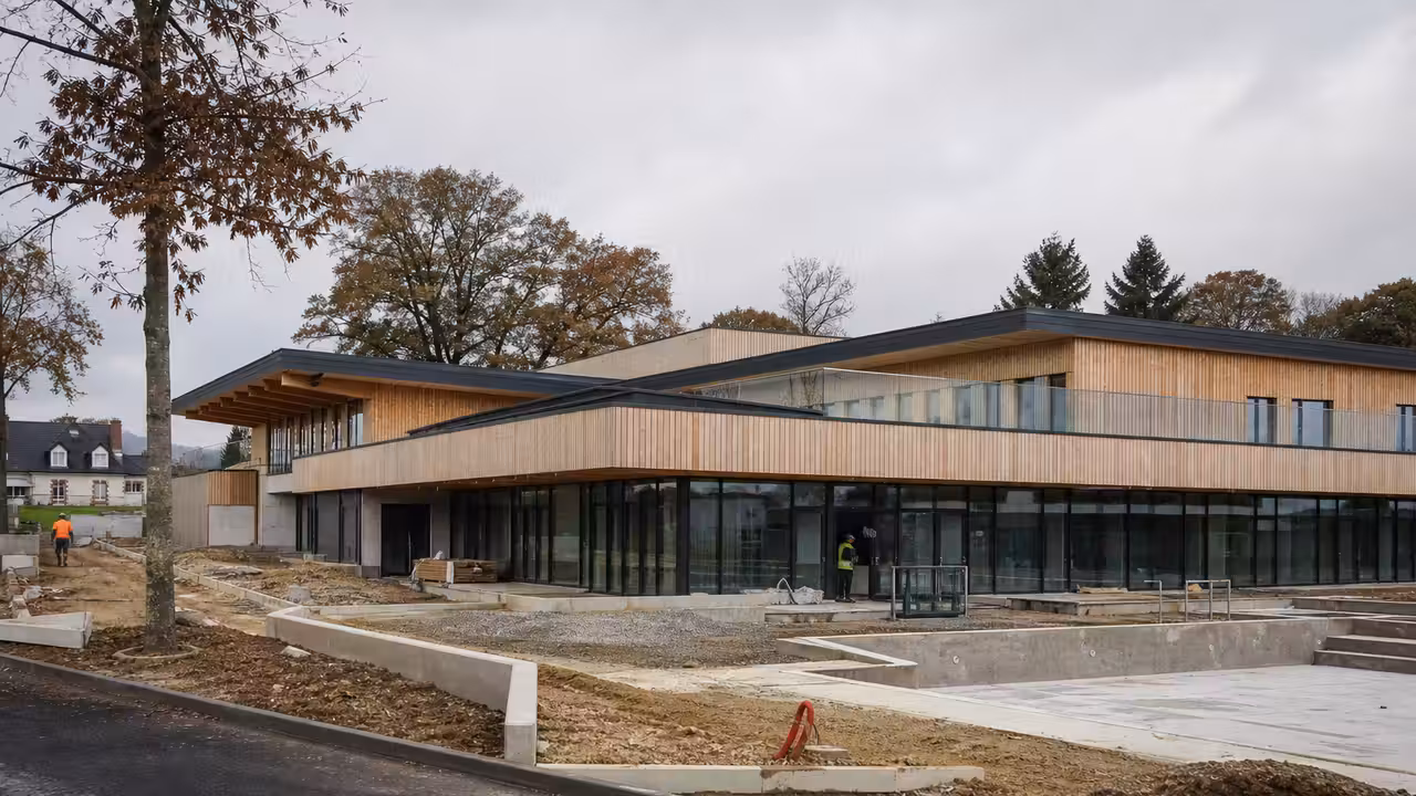 Façade contemporaine d’un centre aquatique avec bassin extérieur et panneaux de signalétique sans texte