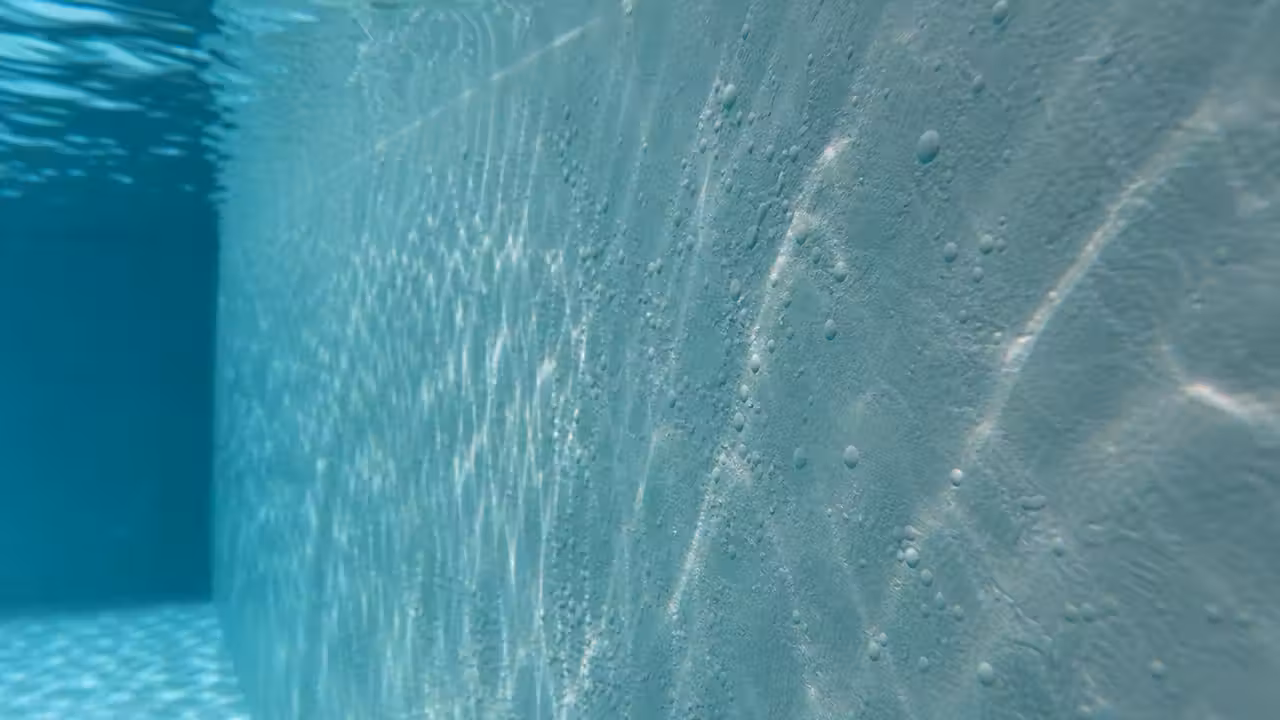 Petites bulles sous le gelcoat d'une piscine coque polyester visibles sur la paroi immergée