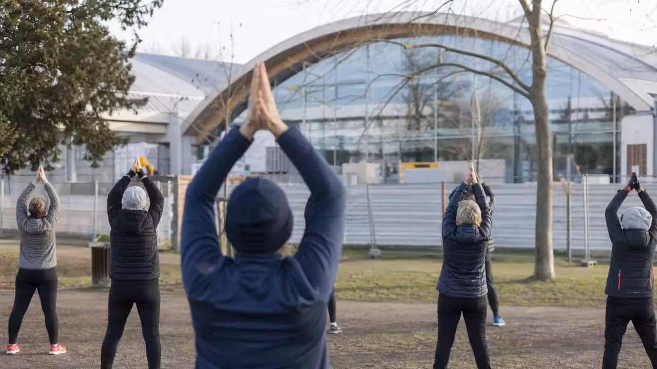 Adhérents adultes suivant une séance de préparation physique en extérieur pendant la rénovation d’une piscine