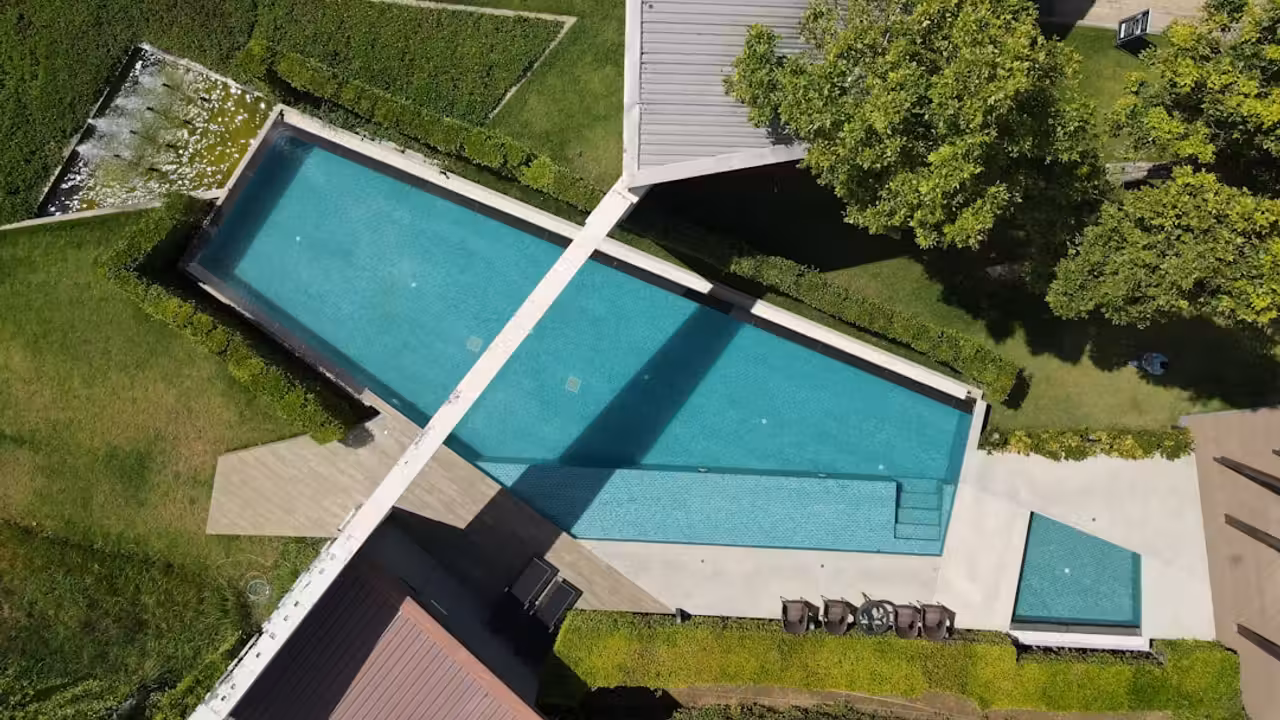 Propriétaire consultant les plans et documents fiscaux d’une piscine enterrée dans son jardin