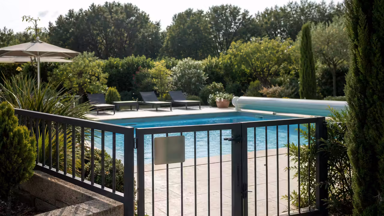 Piscine privée sécurisée avec terrasse et portillon, prête à accueillir des utilisateurs dans un cadre résidentiel.