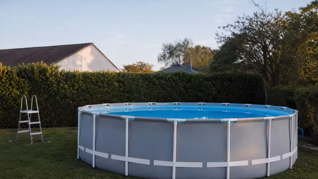Piscine hors sol tubulaire avec sangle périphérique et échelle retirée dans un jardin sécurisé