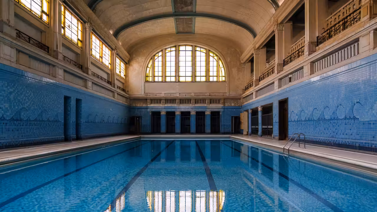 Bassin de la Piscine Saint-Georges à Rennes, bordé de mosaïques bleues et d’une frise ondulante