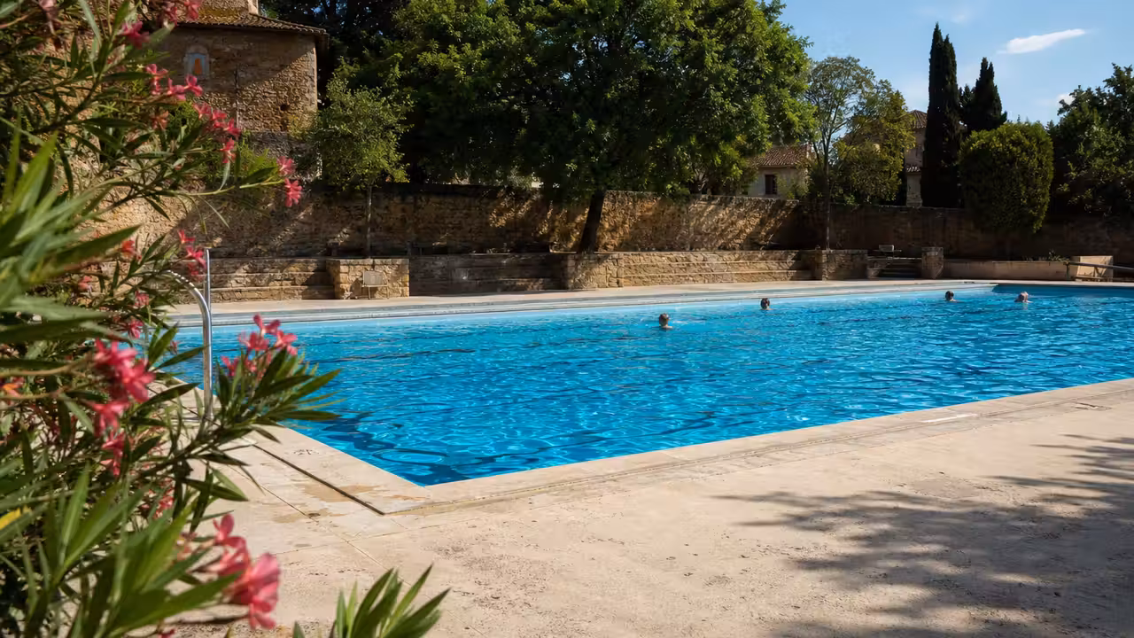 Bassin extérieur de piscine municipale entouré de plages claires dans une bastide du Sud-Ouest
