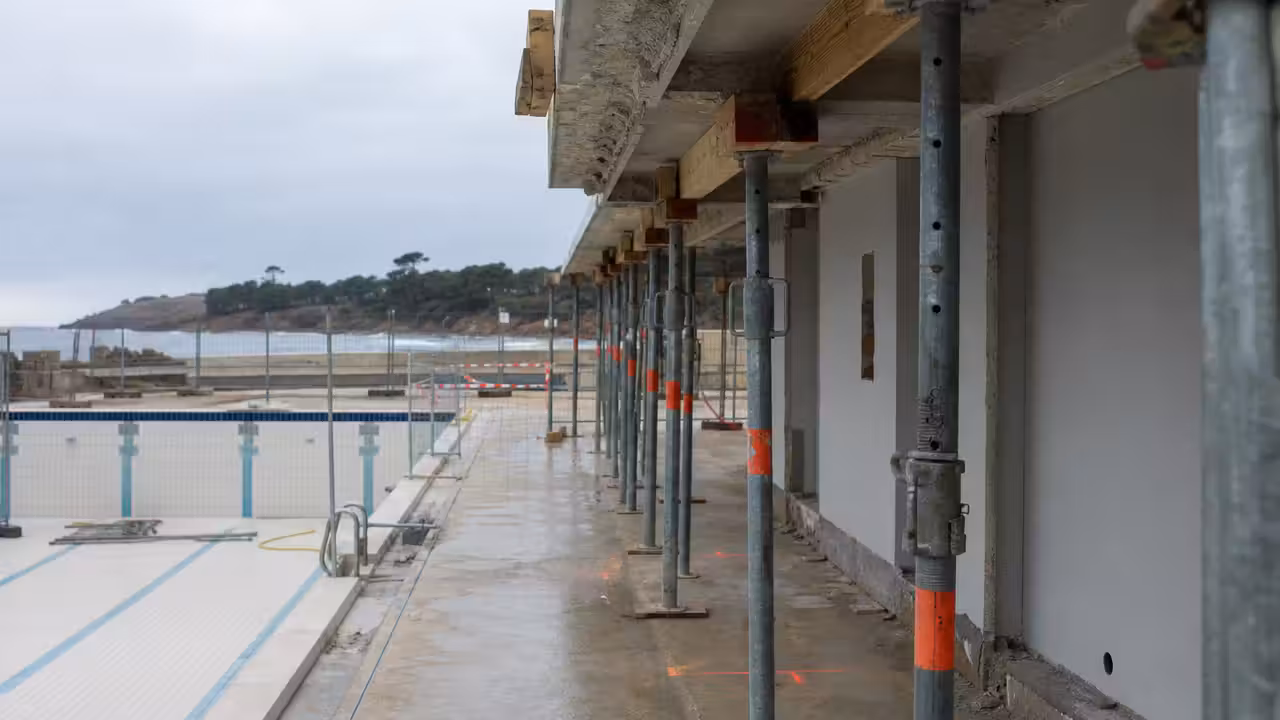 Étais métalliques et barrières de sécurité autour d’un bassin extérieur municipal fermé pour travaux