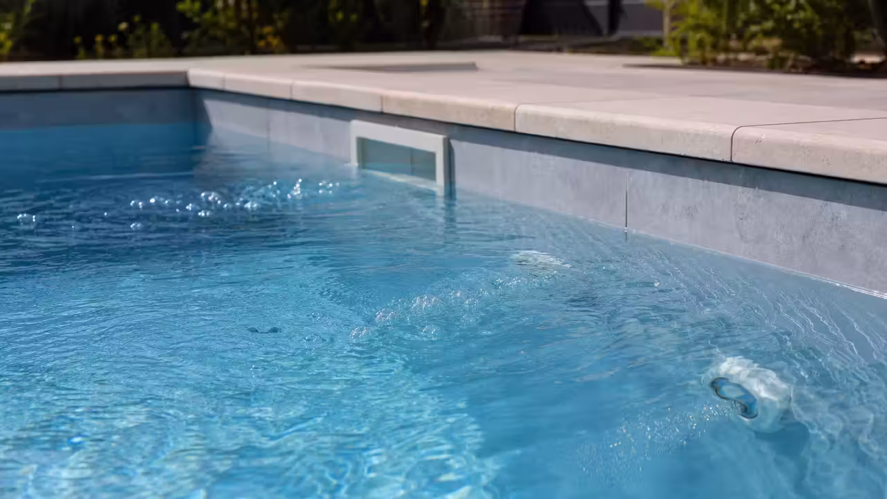 Surface d'une piscine avec de légères ondulations devant des buses de refoulement en fonctionnement