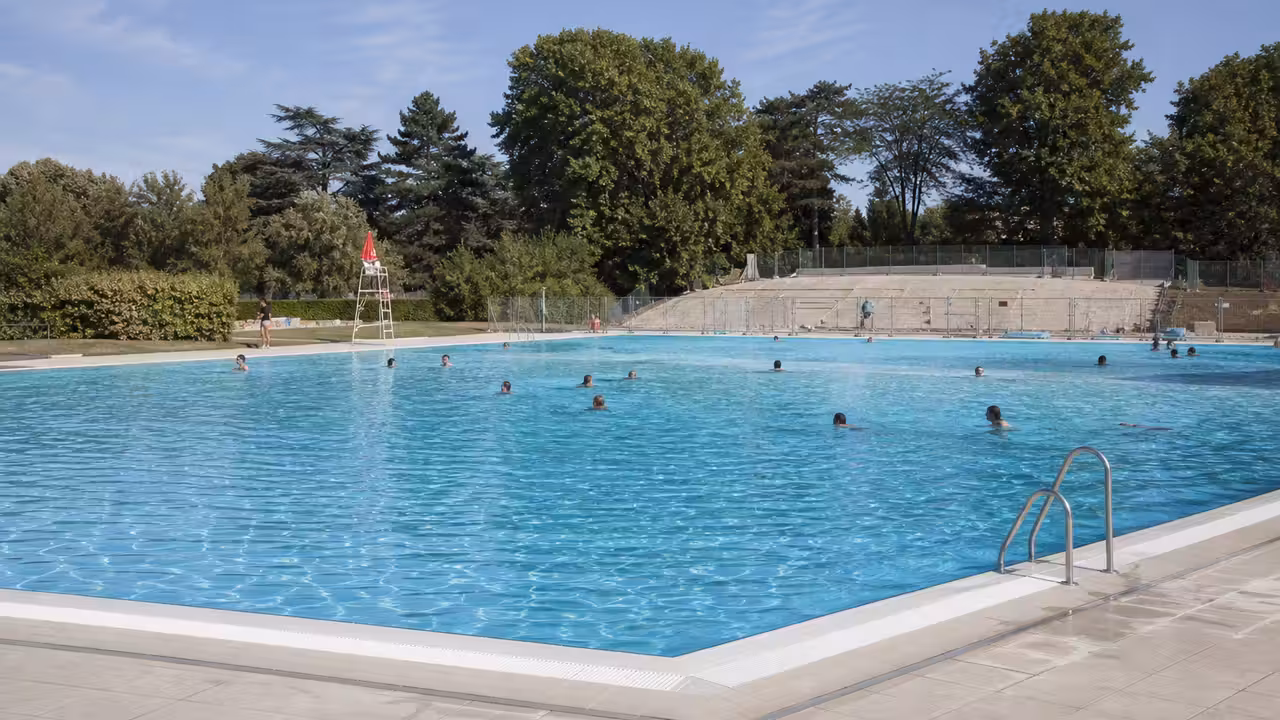 Bassin extérieur de piscine publique sans toboggan, avec plages minérales et zone de baignade surveillée