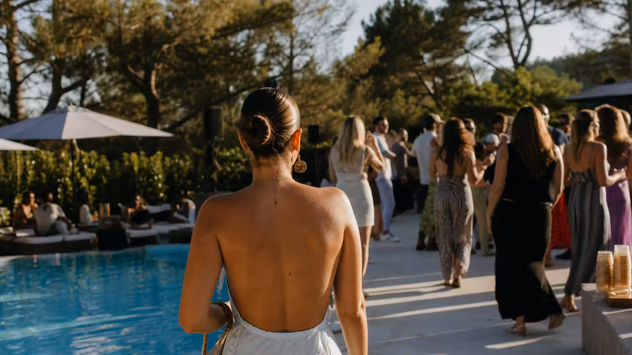 Ambiance de pool party au bord d’une piscine d’hôtel, avec espace de danse éloigné de l’eau