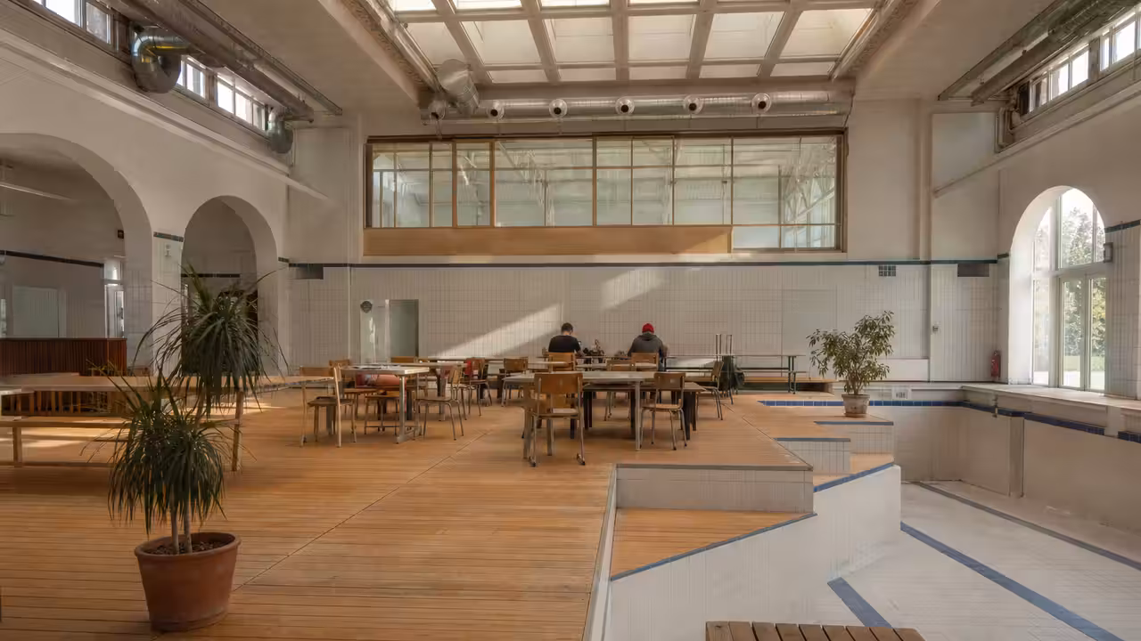Ancien bassin municipal reconverti en espace collectif lumineux avec ateliers et mobilier modulable