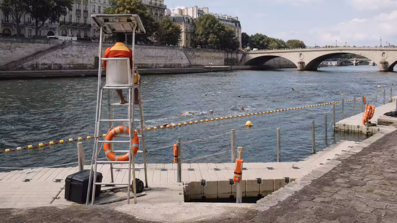 Zone de baignade surveillée sur la Seine avec ponton, bouées de délimitation et berges parisiennes
