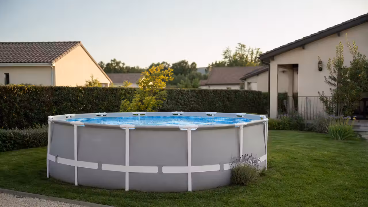 Piscine hors-sol ronde dans un jardin, avec échelle amovible retirée et abords dégagés autour du bassin
